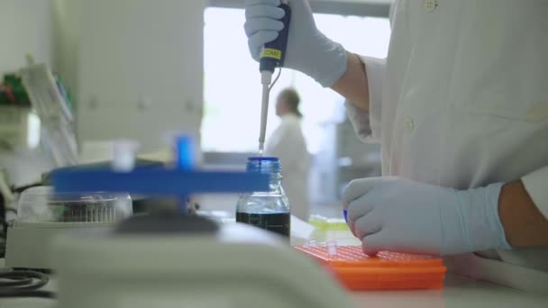 Naukowiec używający pipety w laboratorium z wirówką — Wideo stockowe