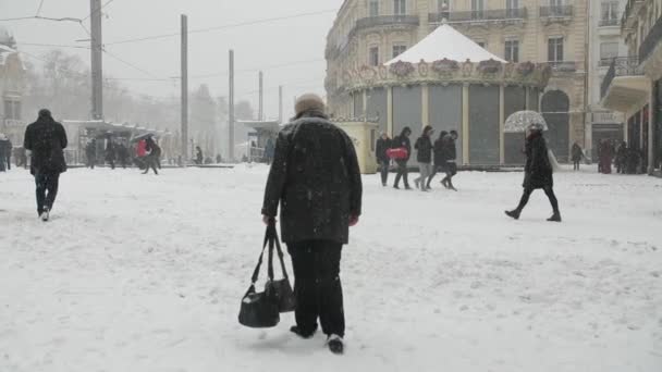 Kvinde går under sneen i Montpellier Comedy Square. Vinter kold sneklædte dag – Stock-video