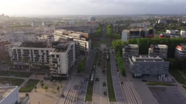 Montpellier Limanı 'ndaki tramvayın üzerinden geri dönen hava aracı Marianne Bölgesi günbatımında ağaçlarla çevrili bir yerleşim yeri.