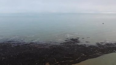 Normandiya 'da bir kayanın üzerinden uçan martılar hava aracı bulutlu bir günde vuruldu.