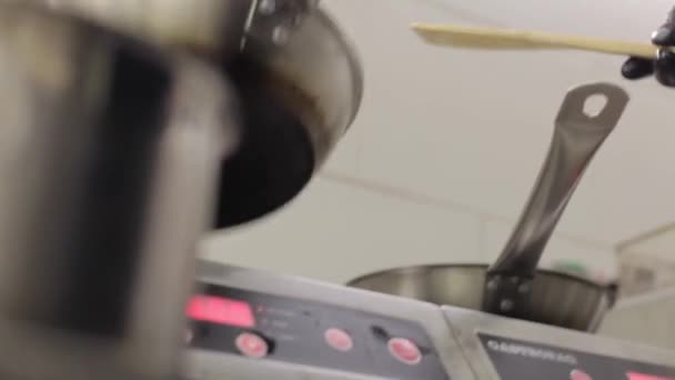 Szef Kuchni Przygotowuje Jedzenie Czarnych Rękawiczkach Żelaznej Patelni Mieszając Jedzenie — Wideo stockowe