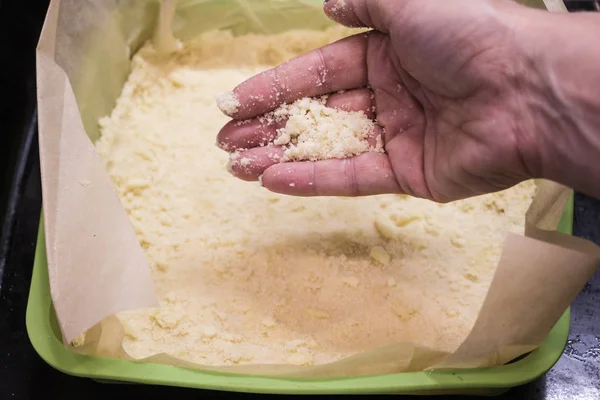 One of the stages of preparation of Apple pie. Woman hands cooking dessert and putting flour into the mold