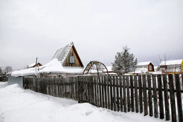 Russian village and wooden house in it in a winter day