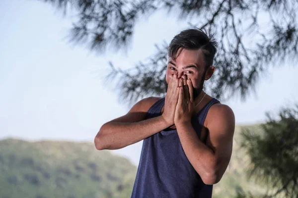 Handsome young man near sea, pine branch and mountain background in a summer day in Turkey