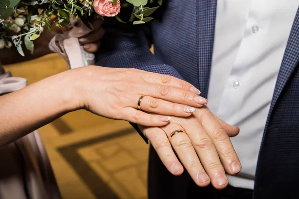 Bride and groom wear rings during the marriage ceremony in registry office