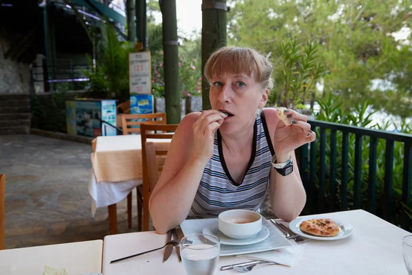 Middle-aged woman at a table in a restaurant on the street. Hotel rest in Turkey