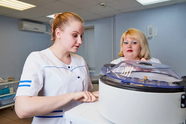 Experienced doctor fat woman teaching aspiring young doctor how to do medical work in laboratories with test tubes