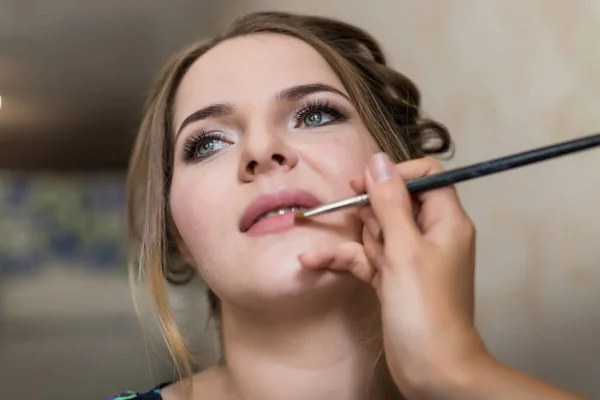 Stylist making makeup for bride on the wedding day