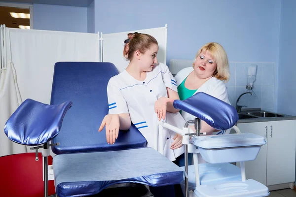 Experienced doctor fat woman teaching aspiring young doctor how to do peculiarities of medical work