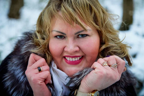 Portrait of beautiful plump woman in a nice winter forest