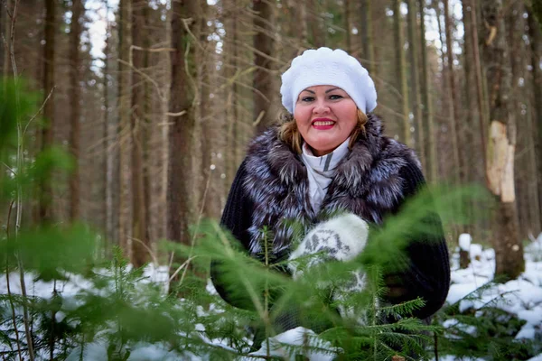 Portrait of beautiful plump woman in a nice winter forest