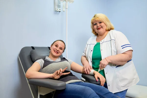 Experienced doctor fat woman taking care of a sick girl on the couch in the medical office