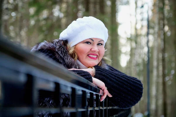 Portrait of beautiful plump woman in a nice winter forest