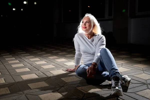 Ugly woman in the city at night with lighting flashes in the black background