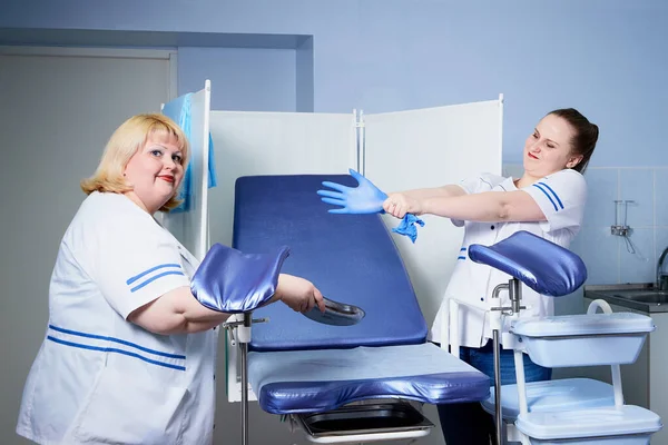 Experienced doctor fat woman teaching aspiring young doctor how to do peculiarities of medical work