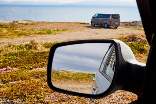 Car Mirror and reflection of tundra and sky in it