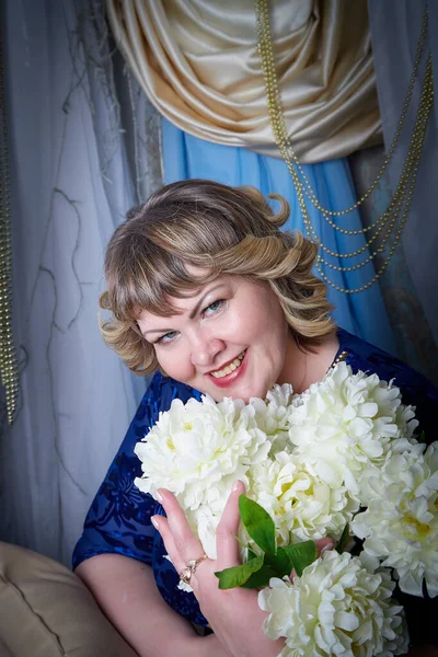 Portrait of beautiful plump chubby woman or girl in the room. Plus size model posing in a nice studio during photoshoot