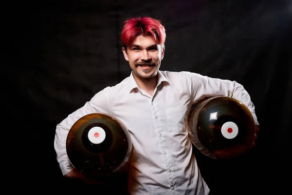 Young handsome guy with red hair in white shirt having fun with beer. Funny man with emotions on face with large bottle of beer and black background. Brewer and barrel. Happy alcoholic with alcohol