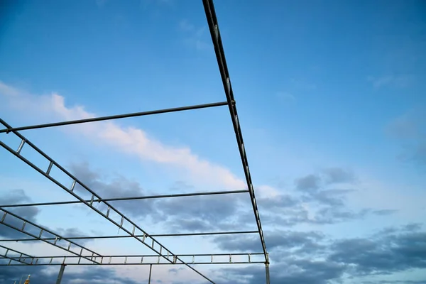 Silhouette of a metal structure and beautiful white clouds in blue sky.