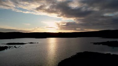 Coll, Hebrides, İskoçya 'daki Ronard Gölü üzerinde gün batımının 4K görüntüsü.
