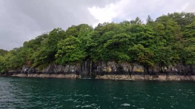 İskoçya 'nın Mull, Argyll ve Bute adasında denize akan bir şelalenin 4k görüntüsü.