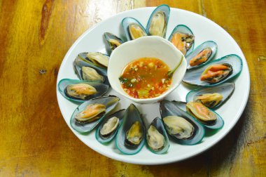  Buğulama midye beyaz plaka üzerinde baharatlı sos ile hizmet