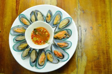  Buğulama midye beyaz plaka üzerinde baharatlı sos ile hizmet