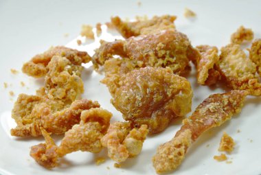  derin kızarmış tavuk cilt ile tuz ve biber beyaz plaka üzerinde