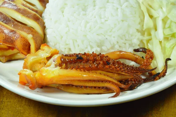 Щупальце кальмара на гриле с ломтиком капусты и имбирем на тарелке — стоковое фото