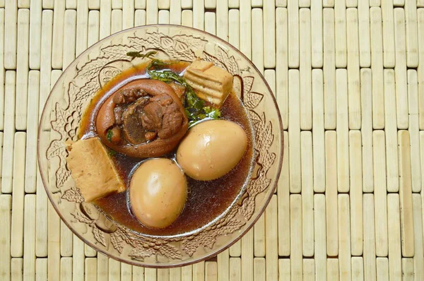 Főtt tojás, az üveg tálba barna gyógynövény levest csülökkel gazdagítva — Stock Fotó