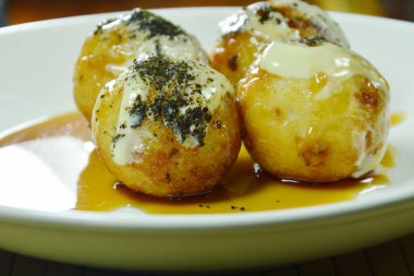 Takoyaki Japonca kızartılmış hamur tatlısı dolması kalamar soyunma mayonez plaka üzerinde tatlı soya soslu püresi yosun daldırma Tepesi