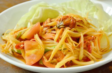 Som tum Tay baharatlı yeşil papaya çanak üzerinde turşu midye salata ile