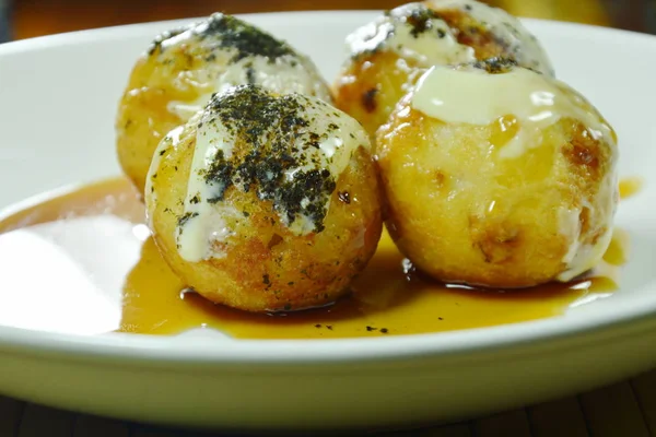 Takoyaki Japonca kızartılmış hamur tatlısı dolması kalamar soyunma mayonez plaka üzerinde tatlı soya soslu püresi yosun daldırma Tepesi