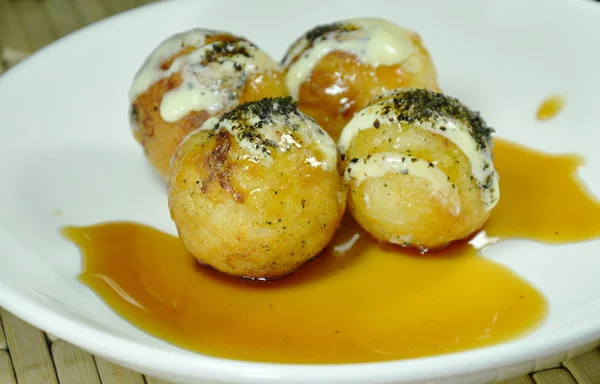 Takoyaki pangsit goreng Jepang diisi cumi-cumi dressing mayones topping rumput laut tumbuk dicelupkan dengan kecap manis di piring — Stok Foto