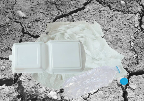 plastic bag bottle and foam box on crack ground background