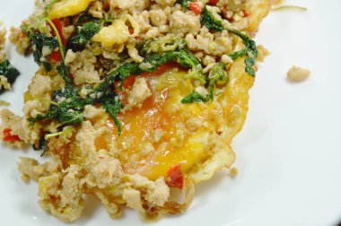 kızarmış yumurta beyaz plaka üzerinde fesleğen yaprağı ile baharatlı kıyılmış domuz Tepesi