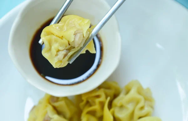 Китайський свинини dumpling підбору в нержавіючої сталі паличками на соєвий соус з футболу — стокове фото