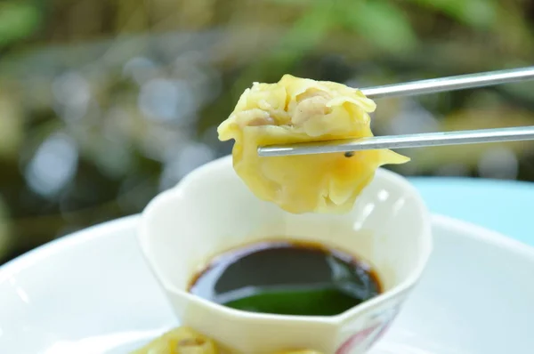 Chinesische Schweineknödel Kommissionierung in rostfreien Essstäbchen auf Sojasauce Tasse — Stockfoto