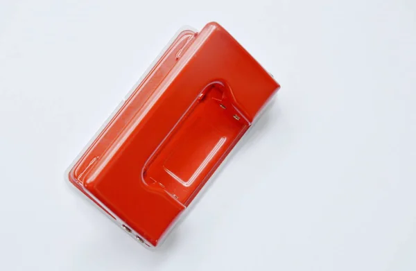 Perfurador vermelho empurrando papel no fundo branco — Fotografia de Stock