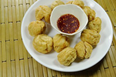 çıtır çıtır kızarmış balık top plaka üzerinde tatlı ve baharatlı sos Kupası ile daldırma