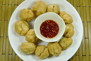 çıtır çıtır kızarmış balık top plaka üzerinde tatlı ve baharatlı sos Kupası ile daldırma