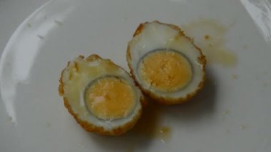 Kızarmış yumurta, yarım kesilmiş tatlı tamarind sosu tabakta kırmızı biber sosu.