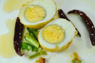 Kızarmış yumurta, yarım kesilmiş tatlı tamarind sosu tabakta kırmızı biber sosu.