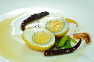 Kızarmış yumurta, yarım kesilmiş tatlı tamarind sosu tabakta kırmızı biber sosu.