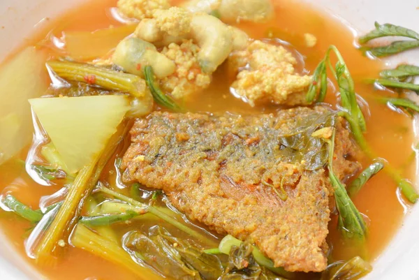 Cozido legumes misturados cobertura peixe frito e ovo em sopa picante tailandesa na tigela — Fotografia de Stock