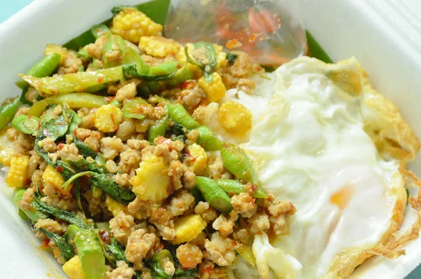 Spicy stir fried minced pork with basil leaf topping egg on rice in white foam box packing — Stock Photo, Image