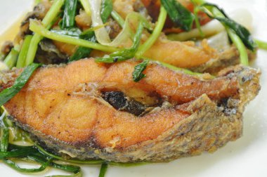  Kızarmış Nil Tilapia ya da mango balığı soslu soya sosu ve tabakta taze soğan.