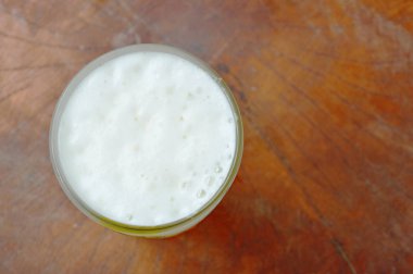  soğuk bir bira ile cam ahşap arka plan üzerinde köpüklü