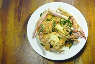  Kızarmış yüzücü yengeç plaka üzerinde sarı köri ilave edin