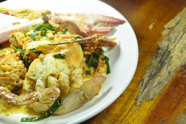  Kızarmış çiçek yengeç plaka üzerinde sarı köri ilave edin